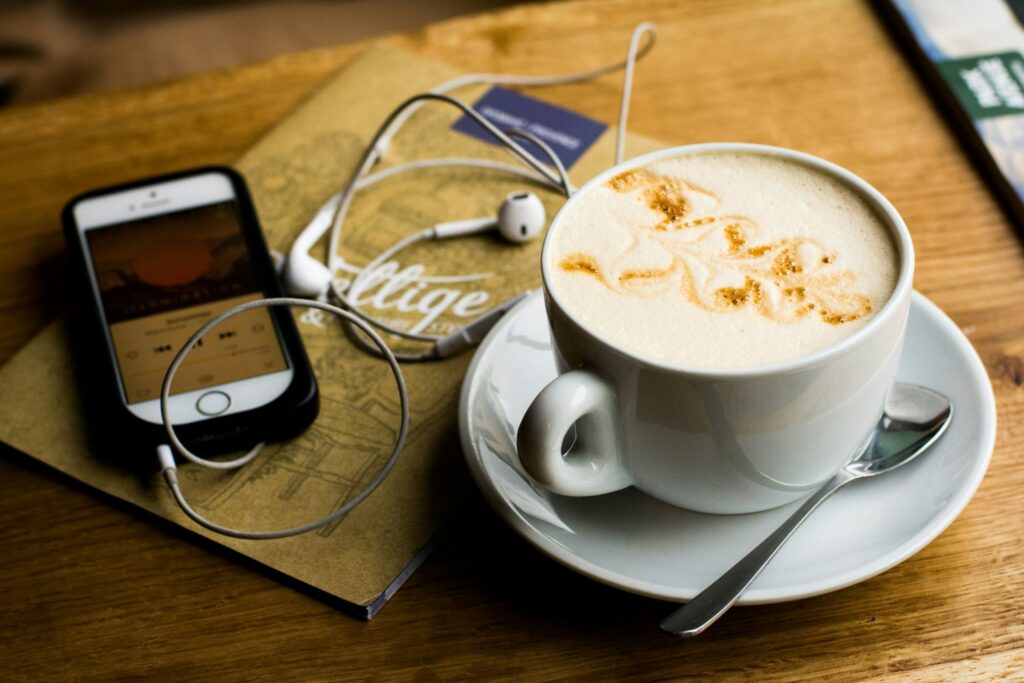 podcast luisteren op smartphone met koffie