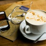 podcast luisteren op smartphone met koffie